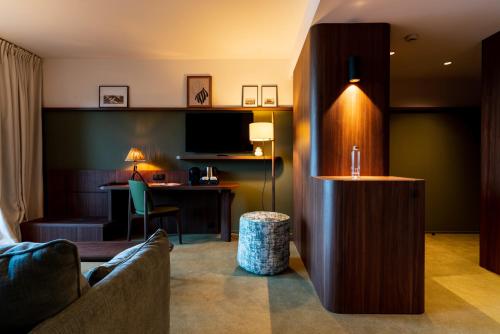 a hotel room with a couch and a desk at Hôtel Roz Marine Thalasso Resort in Perros-Guirec