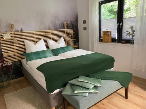 a bedroom with a large bed with green sheets at Schmidtsches Quartier in Hain