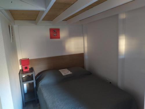 Cette petite chambre comprend un lit et une petite table. dans l'établissement La Barque, au Barcarès
