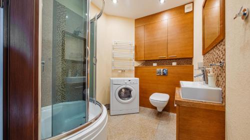a bathroom with a washing machine and a sink at Apartamenty Sun & Snow Melioracyjna in Karwia