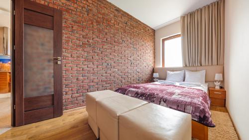 a brick walled bedroom with a bed and a brick wall at Apartamenty Sun & Snow Melioracyjna in Karwia