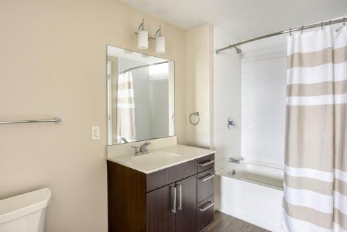 uma casa de banho com um lavatório, um WC e um espelho. em Blueground E Cambridge gym wd near T stop BOS-967 em Boston