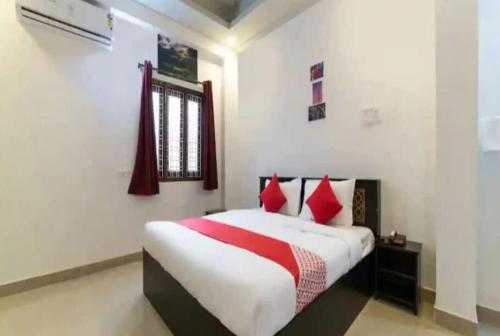 a bedroom with a bed with red pillows at OYO HOTEL FORTUNE BLISS in Hyderabad