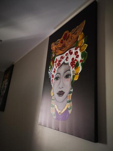 a painting of a woman wearing a floral headdress at B&B Tonnarella Beach in Torre Forte