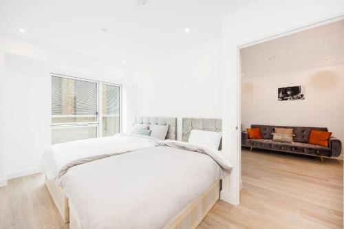 1 dormitorio blanco con 1 cama grande y 1 sofá en Heads on Bed- London Excel Royal Victoria Dock O2, en Londres
