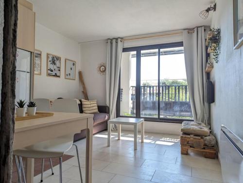 sala de estar con mesa y ventana grande en Appartement à Seignosse Le Penon - 200m plage, en Seignosse