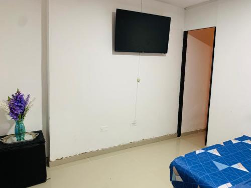 a room with a bed and a tv on a wall at Hotel Belmar piso 2 in Cartagena de Indias
