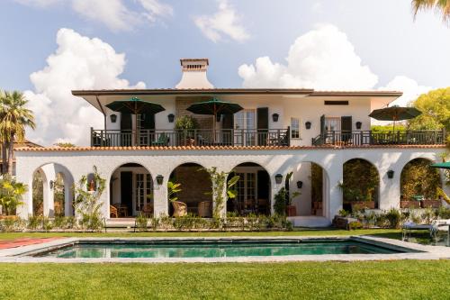 a house with a pool in front of it at California Park Hotel in Forte dei Marmi