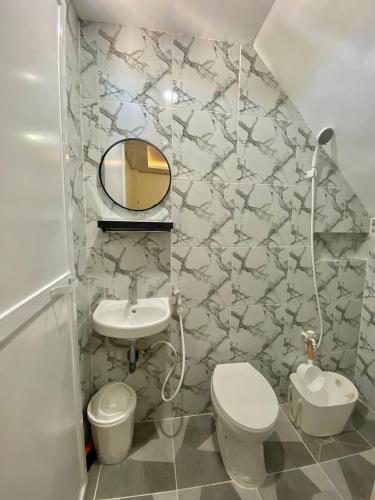 a bathroom with a sink and a toilet and a mirror at Second Pad at Second floor in Bolinao