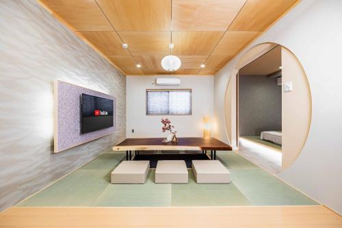 a dining room with a table and a tv at JAPAVISTA Fuji in Osaka