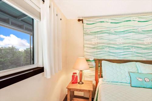 a bedroom with a bed and a window with a painting at Whale Song Condo #29 in Moclips