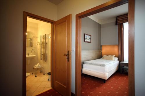 a bedroom with a bed and a bathroom at Hotel Paris in Mariánské Lázně