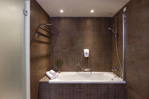 uma casa de banho com banheira e chuveiro em Rodos Princess Beach Hotel em Kiotari