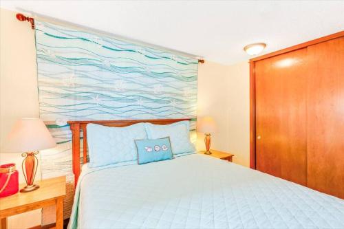 a bedroom with a bed with a painting on the wall at Whale Song Condo #29 in Moclips