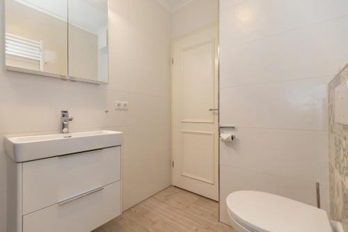 屈赫隆斯博爾恩的住宿－Haus Atlantik，白色的浴室设有卫生间和水槽。