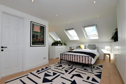 ロンドンにある2 Bed House with garden - 20mins to London Stadiumのベッドルーム1室(ベッド1台、白黒のラグ付)