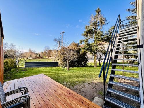 a porch with a wooden deck with stairs and a yard at Fewo im Taubenhaus in Bad Lausick