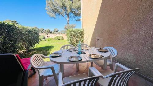 une table blanche et des chaises sur une terrasse dans l'établissement Appartement Cocody 41 LUMIO, à Lumio