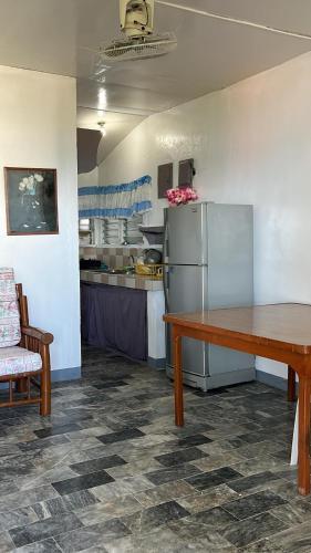 uma cozinha com uma mesa e um frigorífico em Villa Sabang Beach Resort em Puerto Galera