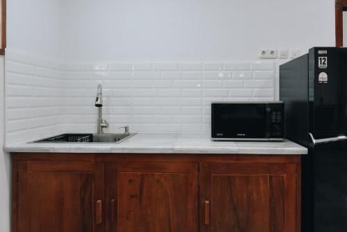 a kitchen with a sink and a microwave at Padma Amita Yogyakarta in Jetis