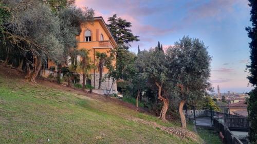 a house on a hill with trees in the foreground at Villa Manzati in Verona