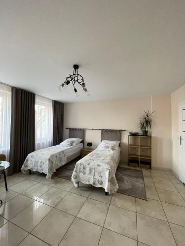 a bedroom with two beds and a chandelier at Ratuszowa 13 in Prudnik