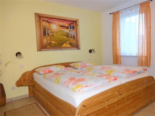 a bedroom with a wooden bed with a picture on the wall at Ferienwohnung mit Terrasse, Garten in Gotha