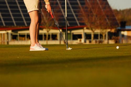 a woman is playing golf on a golf course at Halmstad Tönnersjö Golfbana in Eldsberga