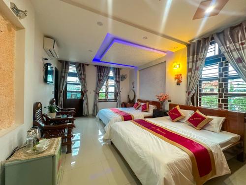 um quarto de hotel com duas camas e uma televisão em RUBY HOMESTAY em Hue