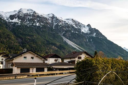 a view of a mountain with houses and a road at Ferienwohnung Schönblick in Weissenbach am Lech