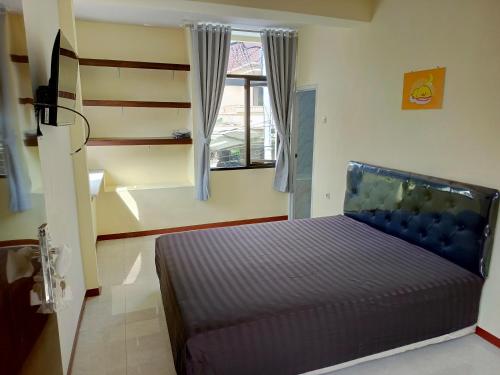 BlimbingにあるBebek Kuning Residenceのベッドと窓のある寝室