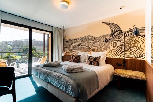 a bedroom with a large bed and a balcony at Hôtel Roz Marine Thalasso Resort in Perros-Guirec