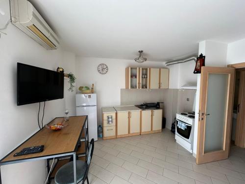 a kitchen with a table and a tv on the wall at Apartment Nadja in Budva