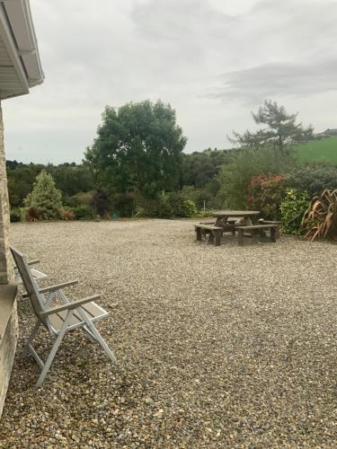 two picnic tables and chairs on a gravel patio at Unyi Ojo in Johnstown