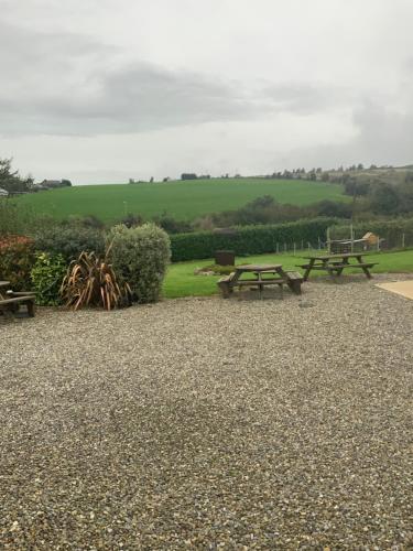 two picnic tables in a park with a green field at Unyi Ojo in Johnstown
