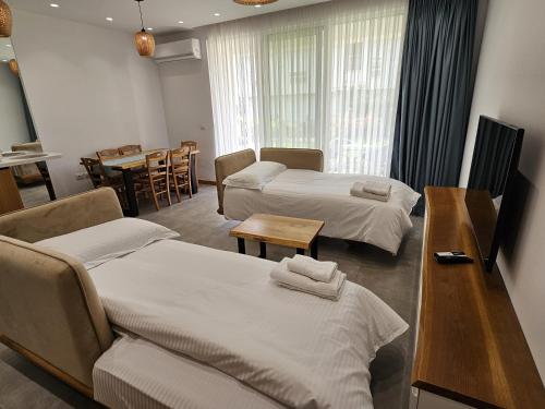 a hotel room with two beds and a table at Pinegrove Apartment in Durrës