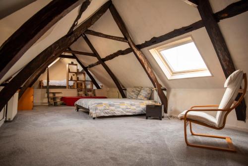a attic bedroom with a bed and a window at La Petite Maison 64 rue Arthur Lamendin in Carvin