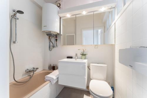 a bathroom with a toilet and a sink and a mirror at Zonnig, ruim appartement op A+ locatie! in Ostend