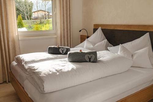 1 cama con 2 almohadas y ventana en Ferienwohnung Schönblick, en Weissenbach am Lech