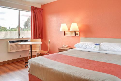 a hotel room with a bed and a desk and a window at Motel 6-Portland, OR - Central in Portland