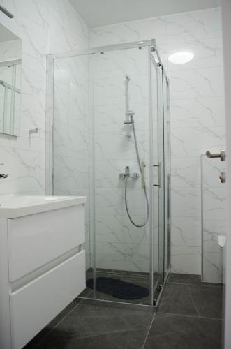 a white bathroom with a shower and a sink at Kuća za odmor 'Luca' in Ljubuški