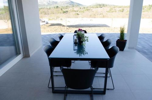 a dining room table with chairs and flowers on it at Kuća za odmor 'Luca' in Ljubuški