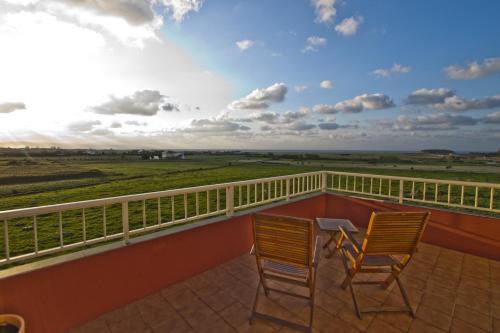two chairs on a balcony with a view of a field at Hotel Mi Norte in Ribadeo