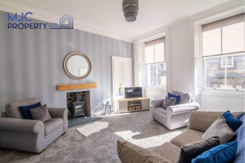 a living room with a couch and chairs and a mirror at The Old Bank in Hawick