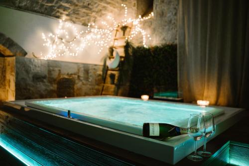 una vasca da bagno con una bottiglia di vino e un bicchiere di Apulia Suite a Castellana Grotte