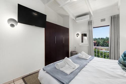 una camera da letto con un letto e due asciugamani di San Lameer Villa 3122 - 3 Bedroom Classic - 6 pax - San Lameer Rental Agency a Southbroom