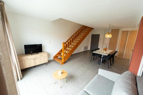 Sala de estar con sofá, TV y mesa en Lagocéan, en Vieux-Boucau-les-Bains