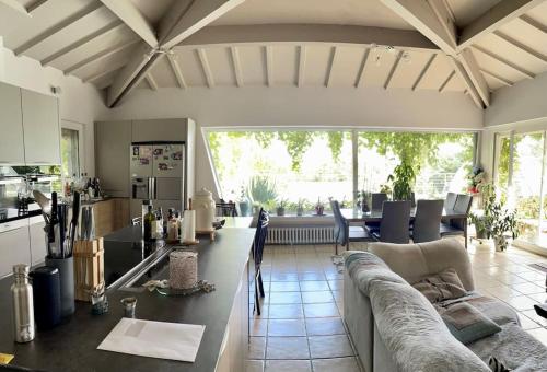 a large living room with a couch and a kitchen at Villa avec piscine au cœur de la ville in Tournon-sur-Rhône