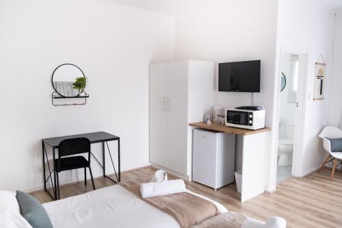 a white living room with a couch and a table at George Lodge International in George