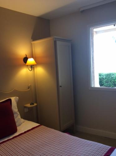 - une chambre avec un lit doté d'une fenêtre et d'une lampe dans l'établissement joli 2 pieces vue mer , piscine proche ste Maxime résidence BELLEVUE, à Roquebrune-sur Argens